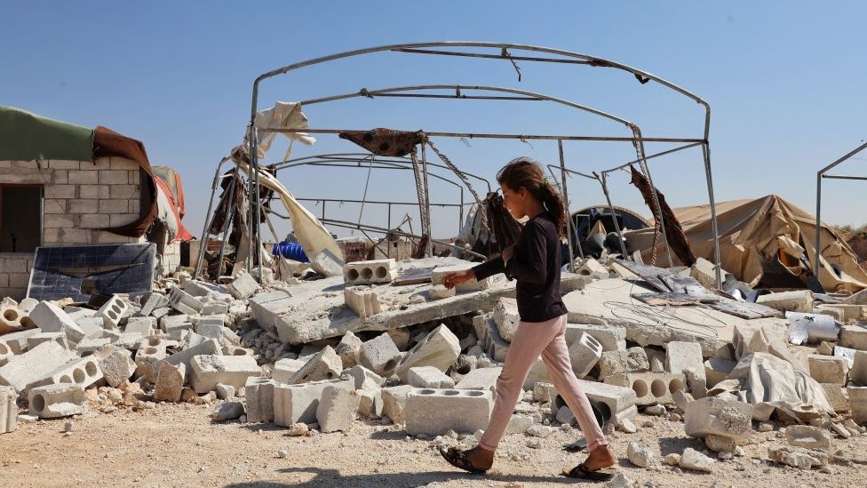 A kid walks on debris at Abrar Refugee Camp after it was hit by Assad Regime's artillery at Taoum district in Idlib, Syria on June 9, 2021.(Photo by Muhammad al-Rifai/NurPhoto via Getty Images)