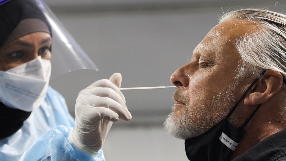 A traveller receives a test for the coronavirus disease (COVID-19) at a pre-departure testing facility, as countries react to the new coronavirus Omicron variant, outside the international terminal at Sydney Airport in Sydney, Australia, November 29, 2021