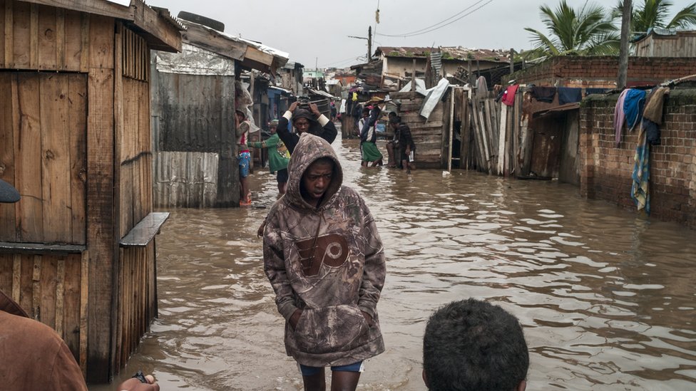 Madagascans walk amidst flooding from a tropical cyclone in the neighborhood of Ankorondrano Andranomahery in the capital Antananarivo, Madagascar, 23 January 2022.