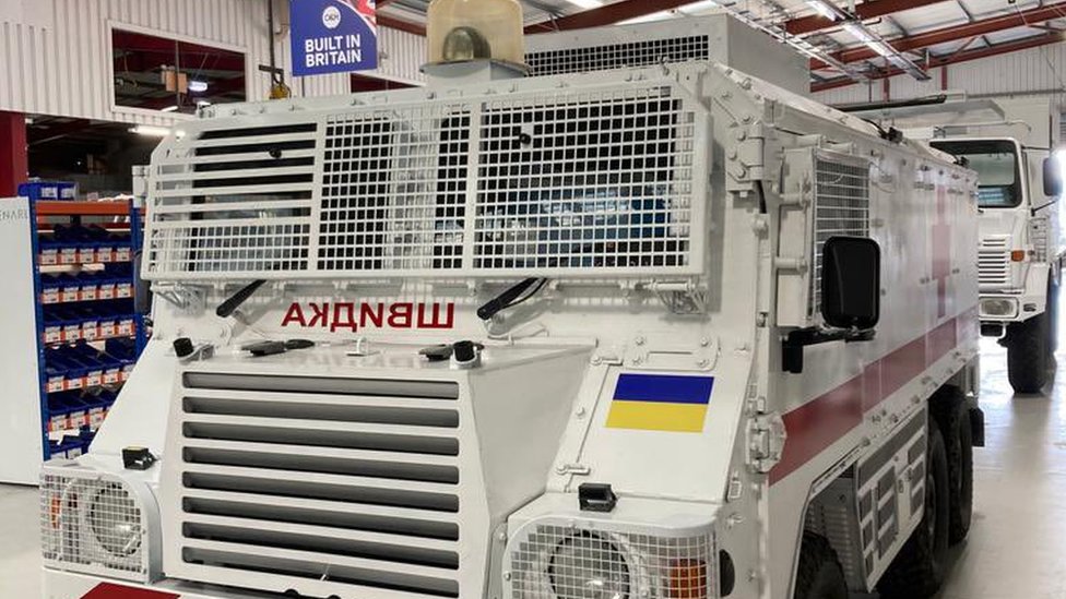 Two armoured ambulances lined up behind each other in a factory