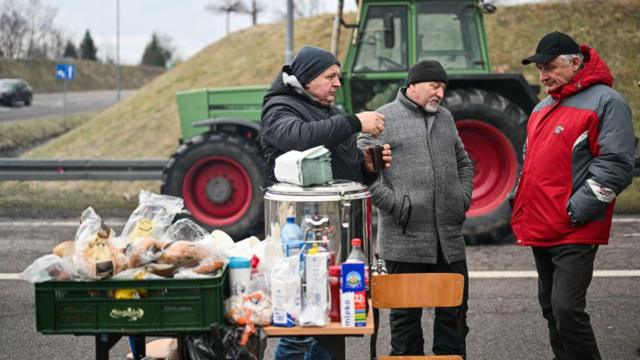 Трое мужчин у столика с едой