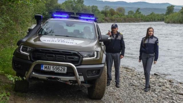 Двое людей в форме на берегу реки