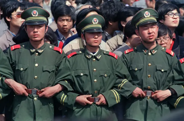 Chinese policemen make a chain to contain a students' demonstration in Beijing on April 27, 1989 during the "Beijing Spring" movement.