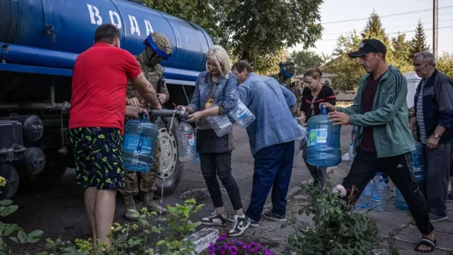 Люди набирают воду в Судже