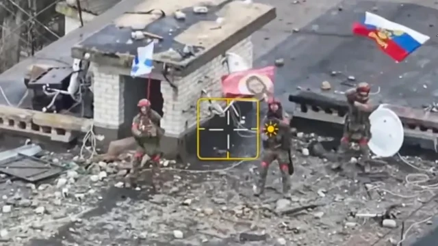 Российские военные с флагом среди развалин