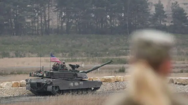 Американский солдат наблюдает за тем, как основной боевой танк армии США M1 Abrams участвует в Международном танковом соревновании армии США в Европе и Африке 11 февраля 2025 года в Графенвёре, Германия