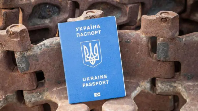Загранпаспорт гражданина Украины виден на фоне уничтоженной российской военной техники на Михайловской площади в Киеве