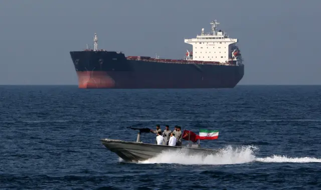 Иранский военный катер проходит мимо очень большого нефтяного танкера в Ормузском проливе 30 апреля 2019 года.