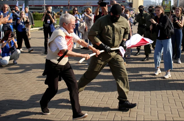 В Минске сносят радиомачту-глушилку; школьникам запрещают иностранное образование; суд отпустил 76-летнюю оппозиционерку. Главное в Беларуси за неделю 2 Багинская на одной из акций протеста в Минске: силовик вырывает у нее из рук красно-белый флаг