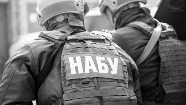 Агент НАБУ в бронежилете и каске, вид со спины