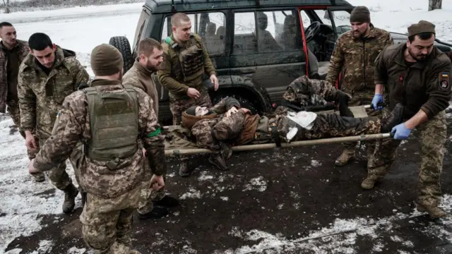 Украинские военные эвакуируют наступившего на российскую противопехотную мину бойца, 29 января 2023 года