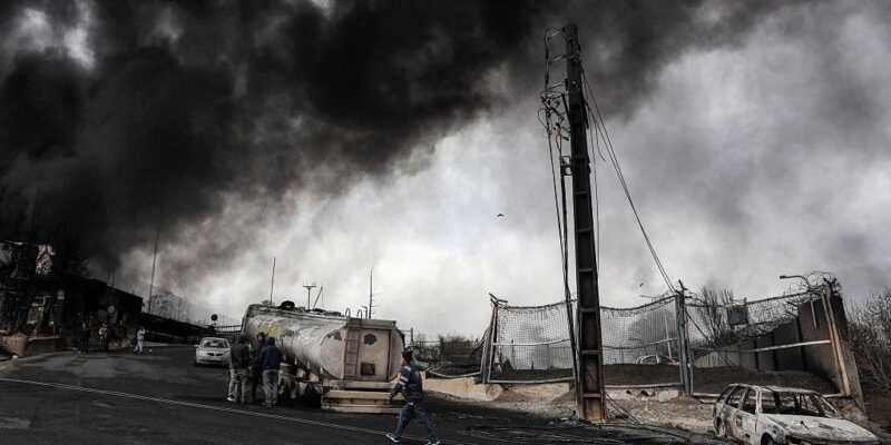 Обугленные машины и клубы дыма рядом с разбомбленным НПЗ "Шахран" в Тегеране