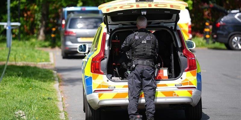 Kenton synagogue attack, image shows police officer stood behind a police car on a leafy street