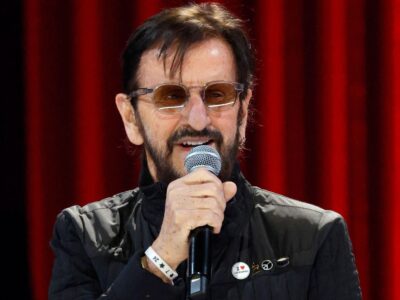 Ringo Starr performs at The Grand Ole Opry on 21 February 2025 in Nashville, Tennessee. He is wearing a black jacket and sunglasses.