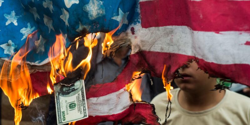 Иранцы жгут флаг и доллары США на демонстрации в Тегеране