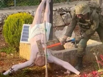Израильский солдат ударяет кувалдой по голове перевернутой статуи Иисуса Христа на юге Ливана. Фото: апрель 2026 г.