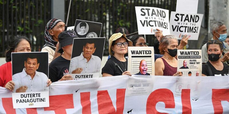 Родственники подозреваемых в наркоторговле, которые, как утверждается, были незаконно убиты по приказу бывшего президента Филиппин Родриго Дутерте, держат портреты Дутерте и его предполагаемых соучастников во время митинга на одной из улиц Манилы 11 марта 2026 года — в первую годовщину ареста бывшего президента и его передачи в Международный уголовный суд (МУС), расположенный в Нидерландах.
