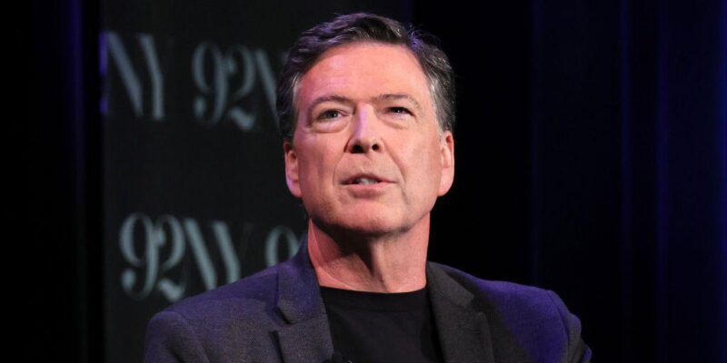 Джеймс Коми в черном пиджаке и черной водолазке с небольшим микрофоном на лацкане.