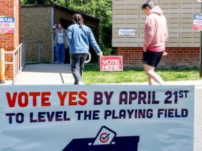 Плакат с надписью «Голосуйте за» у входа в избирательный участок в начальной школе Абингдона во время голосования в Арлингтоне, штат Вирджиния, США, 21 апреля 2026 года.