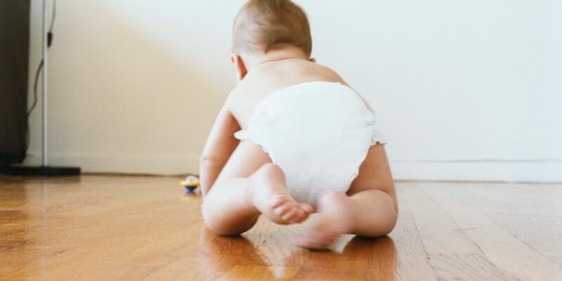 Ребенок ползает по деревянному полу