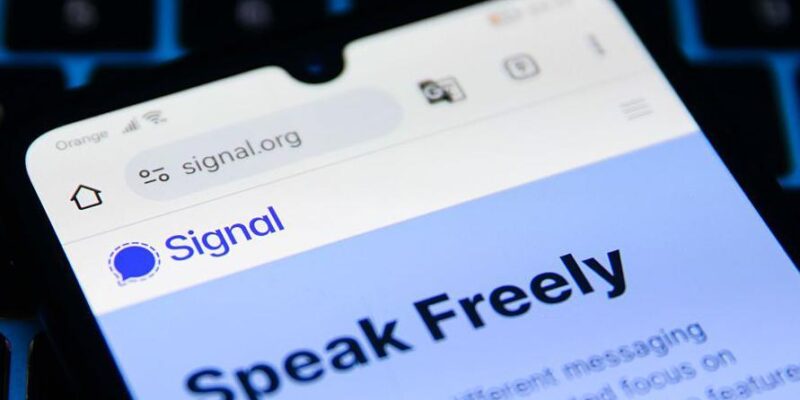 экран телефона с открытым мессенджером Сигнал и надписью на английском "Говори свободно"