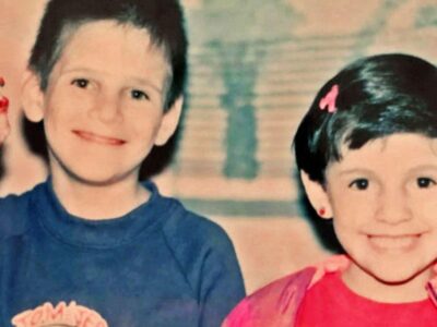 «Он стал другим человеком». Как несостоявшийся актер Голливуда превратился в звезду маносферы 4 A boy in a blue top and a girl in a pink top, both with dark hair, smile at the camera - the boy is holding up a toy figurine