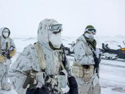 Численность армии Канады растет самыми быстрыми темпами за 30 лет. Дело не только в Трампе 1 Трое канадских военнослужащих на заснеженном фоне в белой камуфляжной форме, с масками на лице и в перчатках, с различными видами боеприпасов в руках. Позади них стоит припаркованный снегоход.