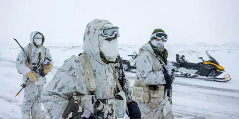 Численность армии Канады растет самыми быстрыми темпами за 30 лет. Дело не только в Трампе 1 Трое канадских военнослужащих на заснеженном фоне в белой камуфляжной форме, с масками на лице и в перчатках, с различными видами боеприпасов в руках. Позади них стоит припаркованный снегоход.