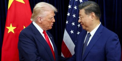 Donald Trump and Xi Jinping pictured shaking hands in front of a Chinese flag and a US flag