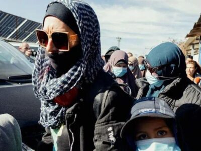 Женщины с закрытыми лицами в головных платках и темных очках у машины