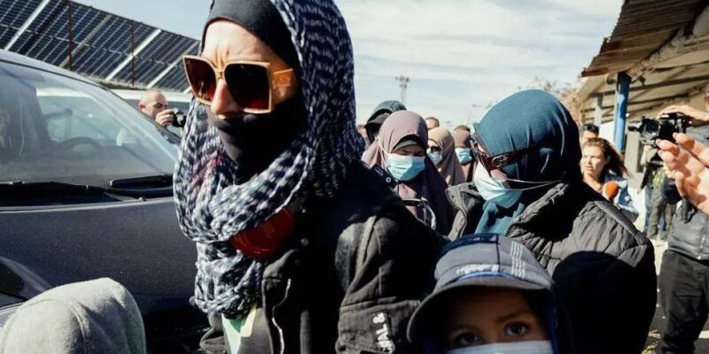 Женщины с закрытыми лицами в головных платках и темных очках у машины