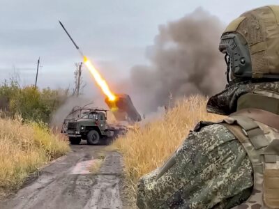 Российский военный (вид со спины) наблюдает за пуском реактивного снаряда из установки «Град»
