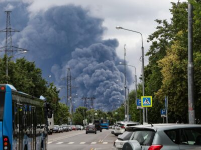Очереди из десятков автомобилей. Наблюдается ли в Москве дефицит бензина? 4 Клубы дыма над Москвой после атак ВСУ 18 июня на фоне проезжей части, на которой видны припаркованные и едущие по дороге автомобили и автобусы