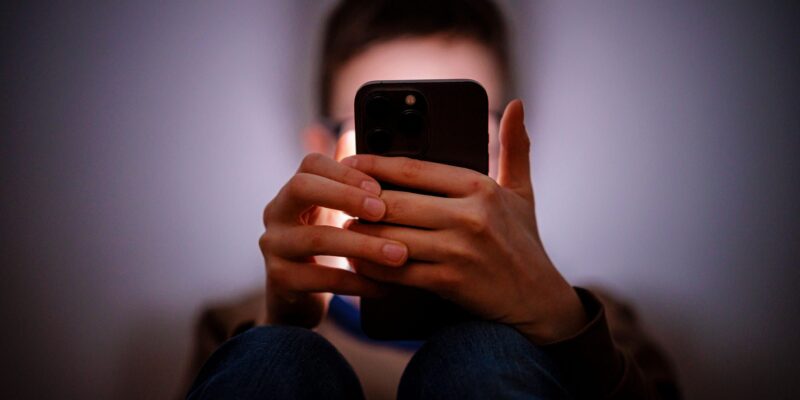 Британский ультиматум Apple и Google: от техногигантов требуют поставить заслон «обнаженке» в телефонах подростков 1 Молодой человек с мобильным телефоном, постановочное изображение