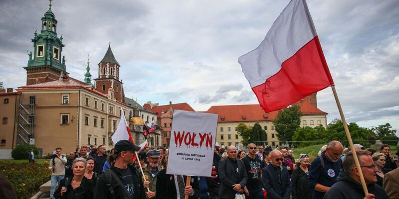 Люди идут с флагами Польши, на транспаранте на переднем плане написано Wołyń, буквы написаны красным и с них стекает кровь