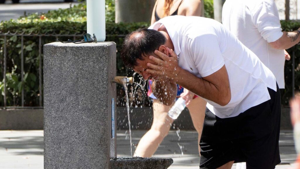 Прогноз — выше 40°C. Во многих странах Европы объявлен красный уровень опасности из-за жары 1 Мужчина умывается у питьевого фонтанчика в Испании. На нем белая футболка и черные шорты