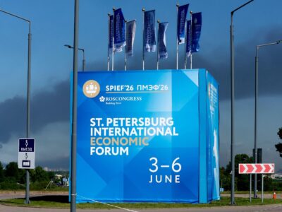 Билборд с рекламой экономического форума, на фоне виден столб черного дыма