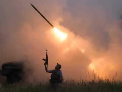 A Ukrainian soldier from the 93rd Kholodnyi Yar Separate Mechanized Brigade of the Ukrainian Armed Forces reacts as his colleagues fire a BM-21 Grad multiple launch rocket system towards Russian troops