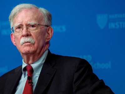 Бывший советник Трампа по национальной безопасности Джон Болтон на синем фоне