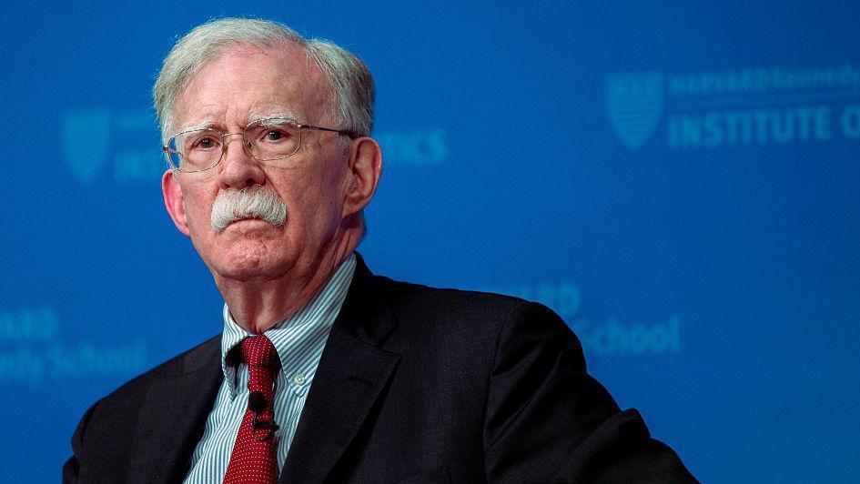 Бывший советник Трампа по национальной безопасности Джон Болтон на синем фоне
