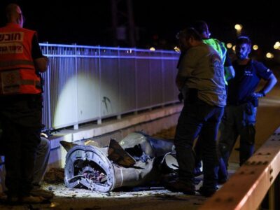 Иран запустил ракеты по Израилю впервые с момента прекращения огня 4 Люди в спецжилетах стоят возле обломков ракеты