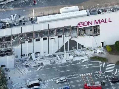 Вид с высоты птичьего полета на торговый центр Aeon Mall с разбитыми окнами и обломками на парковке