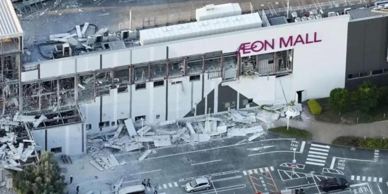 Вид с высоты птичьего полета на торговый центр Aeon Mall с разбитыми окнами и обломками на парковке