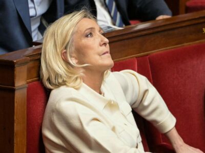 Судьбоносный момент: решение суда по делу Марин Ле Пен определит ход президентской кампании во Франции 2 Марин Ле Пен сидит в кресле из красного бархата в зале заседаний Национального собрания Франции. Она кусает губу и смотрит вверх. Одета в костюм кремового цвета.