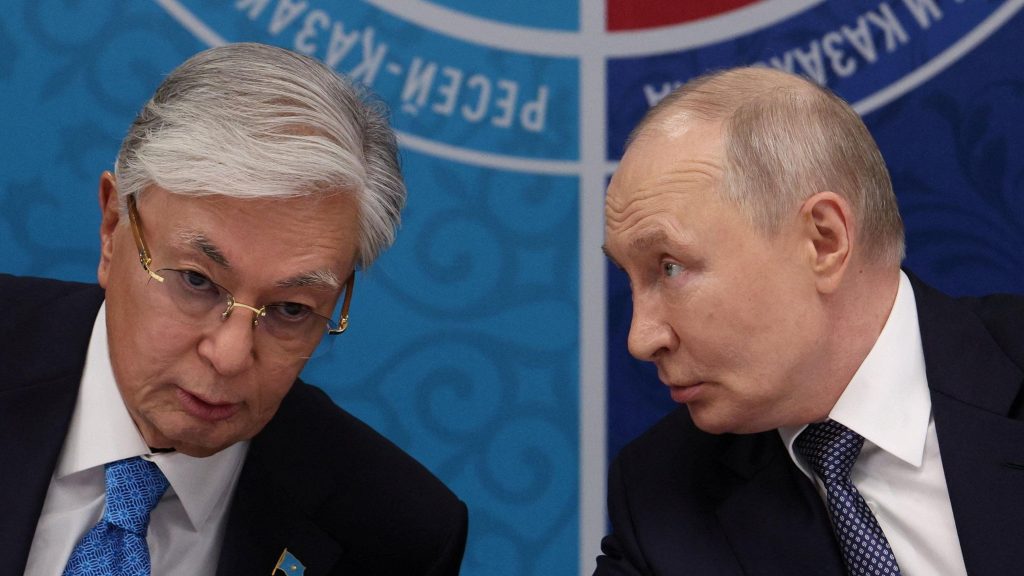 Токаев и Путин за столом о чем-то говорят.
