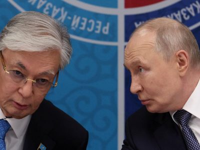Токаев и Путин за столом о чем-то говорят.