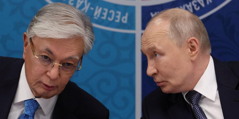 Токаев и Путин за столом о чем-то говорят.
