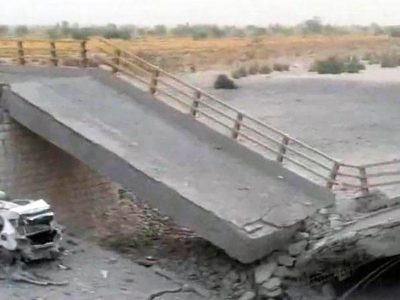A damaged portion of the bridge in the aftermath of the overnight strike in Bandar Khamir, Hormozgan province. The image shows a portion of the bridge collapsed with rubble surrounding it, it is positioned diagonally with a damaged car
