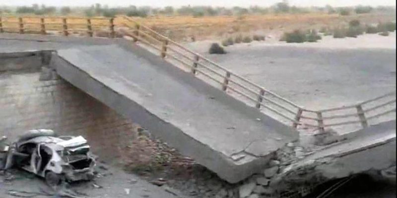 A damaged portion of the bridge in the aftermath of the overnight strike in Bandar Khamir, Hormozgan province. The image shows a portion of the bridge collapsed with rubble surrounding it, it is positioned diagonally with a damaged car