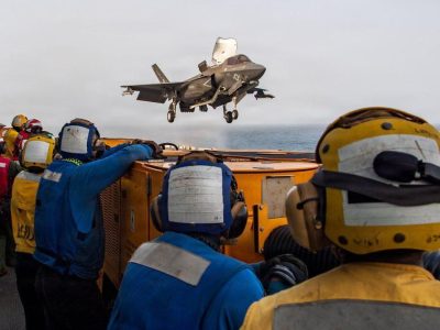 США нанесли новые удары по Ирану, Трамп пригрозил возмездием за гибель американских солдат 2 Американские военнослужащие на борту десантного корабля USS Boxer наблюдают за американским истребителем в полете. Фото из архива